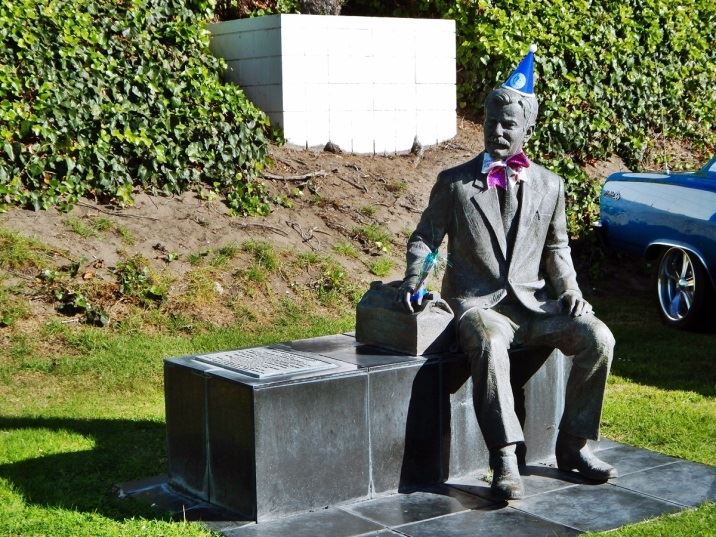 Statue of John Roberts wearing a birthday hat outside on City Hall lawn